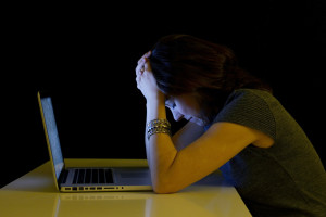Young student woman alone  with computer crying sad depressed